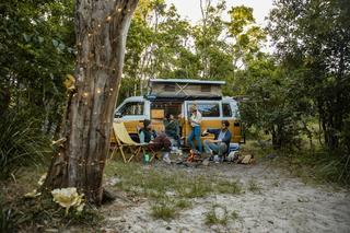 Young people relaxing by the campfire at Waves Campground in Crescent Head