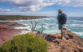 Man enjoying the scenic coastal views from Pulpit Rock in Beowa National Park.