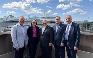 Industry leaders at MCA with cruise ship in background