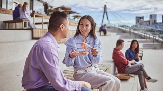 Couple enjoys a seafood meal on the steps of the Sydney Fish Market in Glebe.
