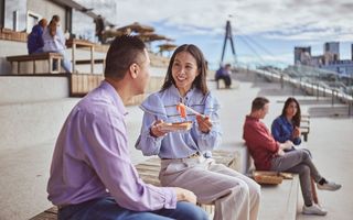 Couple enjoys a seafood meal on the steps of the Sydney Fish Market in Glebe.