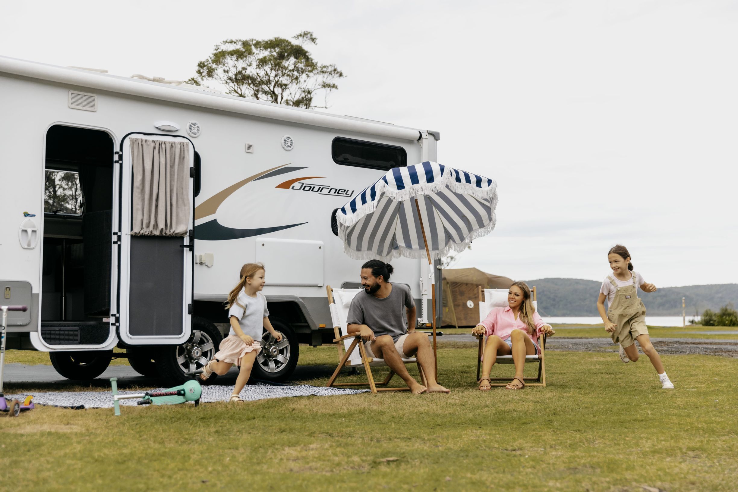 A family having fun in front of a caravan at Ocean Beach Holiday Resort in Umina.