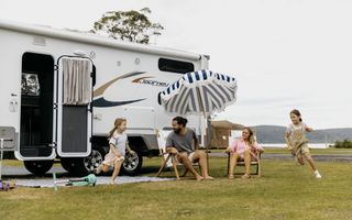 A family having fun in front of a caravan at Ocean Beach Holiday Resort in Umina.