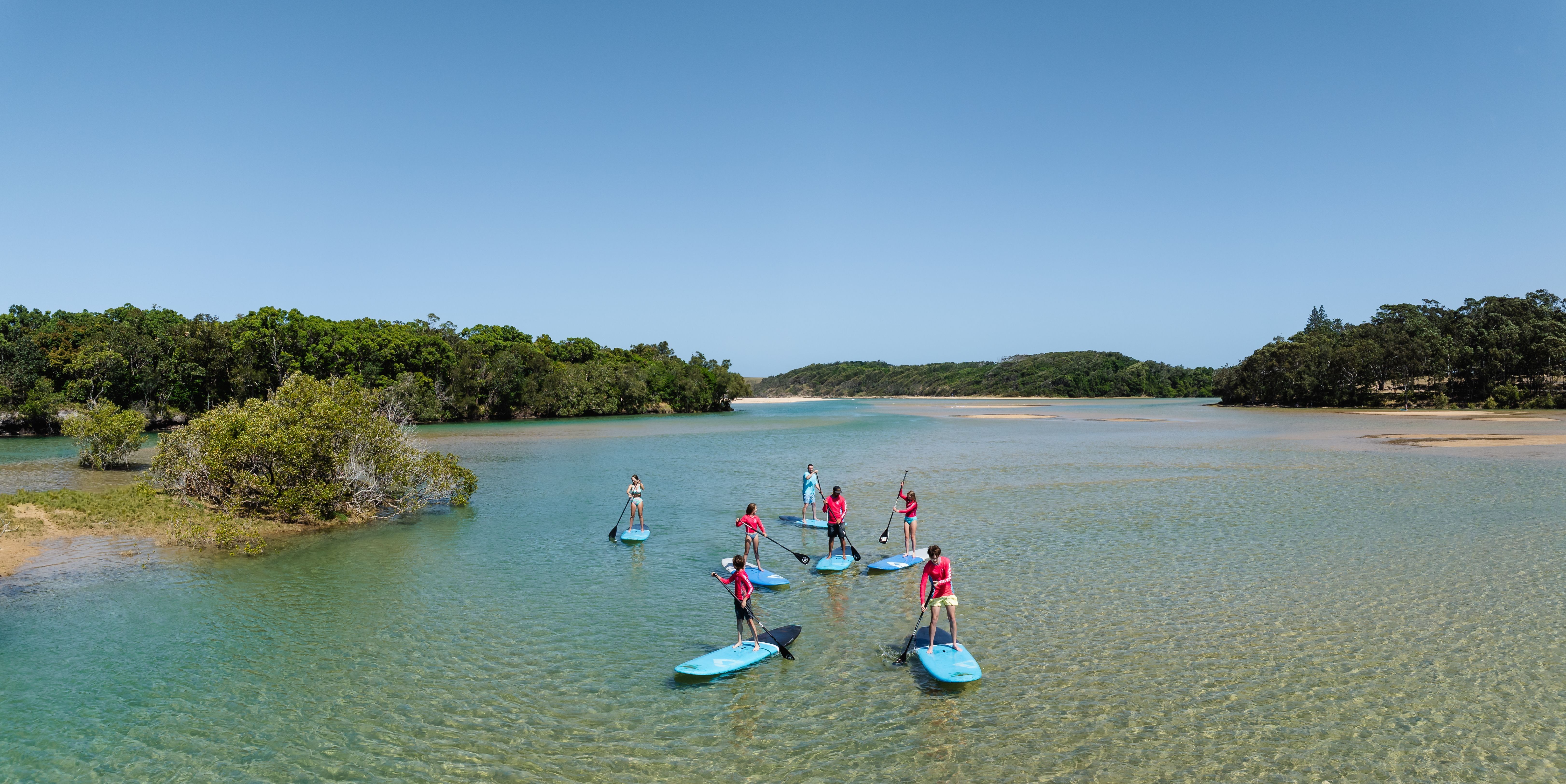 Group of visitors paddle boarding in Coffs Harbour