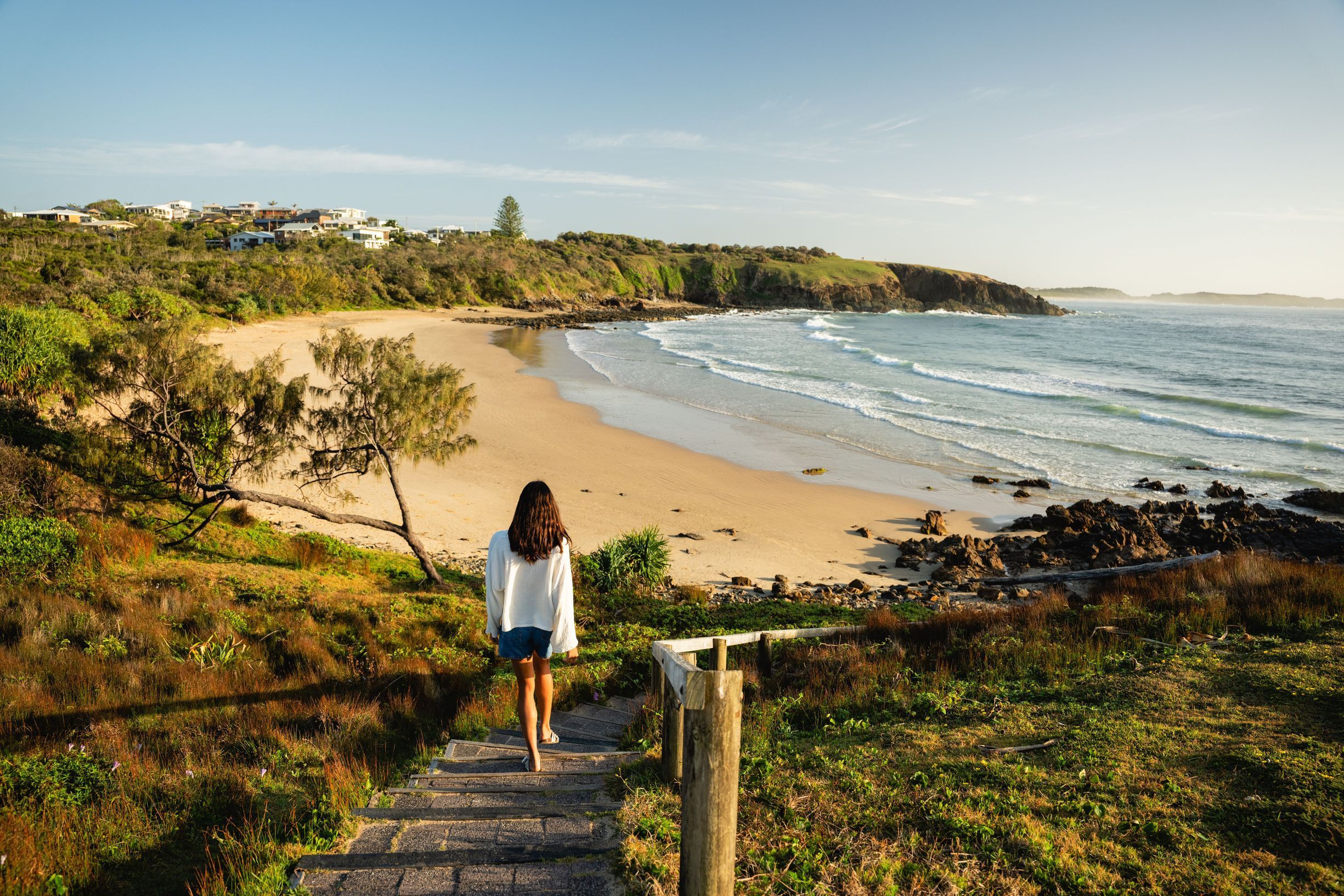 Woman walking down to Emerald Beach