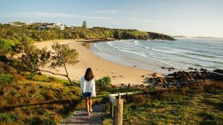 Woman walking down to Emerald Beach