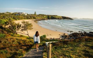 Woman walking down to Emerald Beach