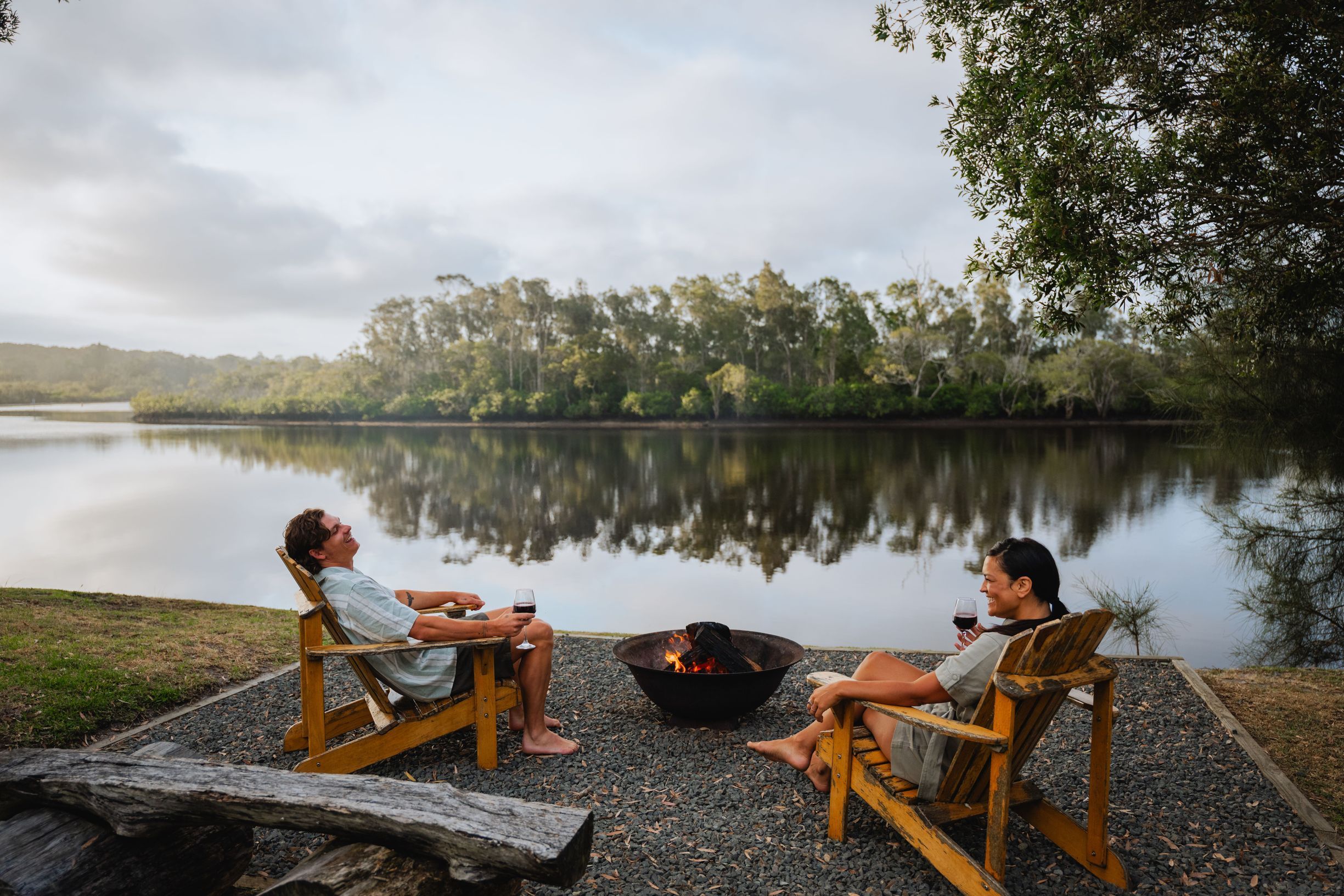Couple enjoying roasting marshmellows by the camp fire at Myall River Camp in Hawks Nest