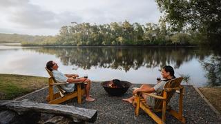 Couple enjoying roasting marshmellows by the camp fire at Myall River Camp in Hawks Nest