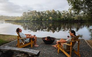 Couple enjoying roasting marshmellows by the camp fire at Myall River Camp in Hawks Nest