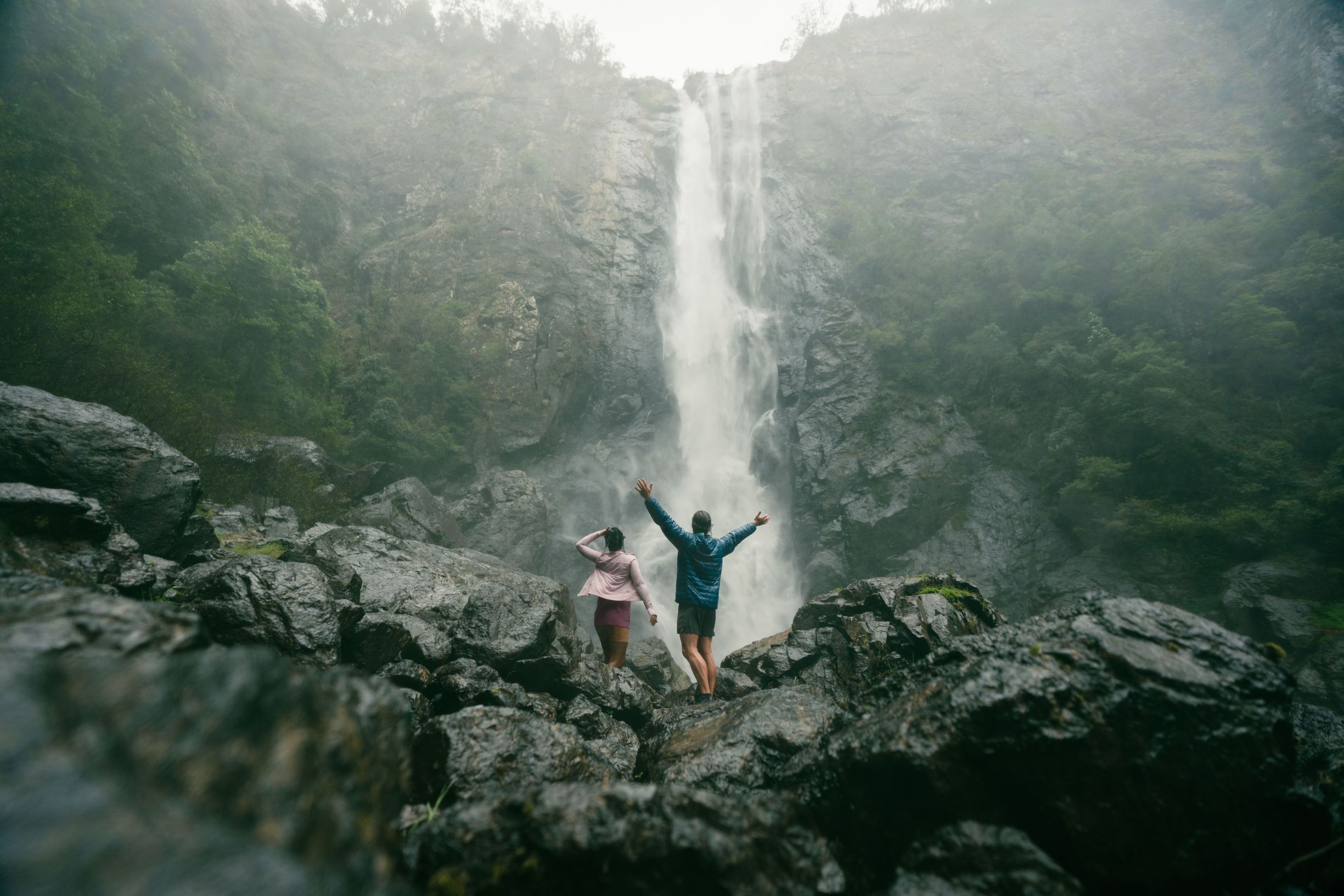 Couple getting soaked under the spray off Ellenborough Falls in Elands