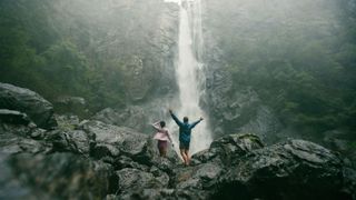Couple getting soaked under the spray off Ellenborough Falls in Elands