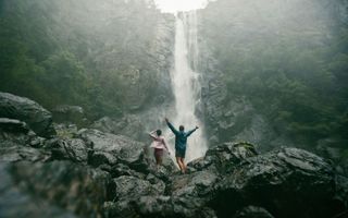 Couple getting soaked under the spray off Ellenborough Falls in Elands