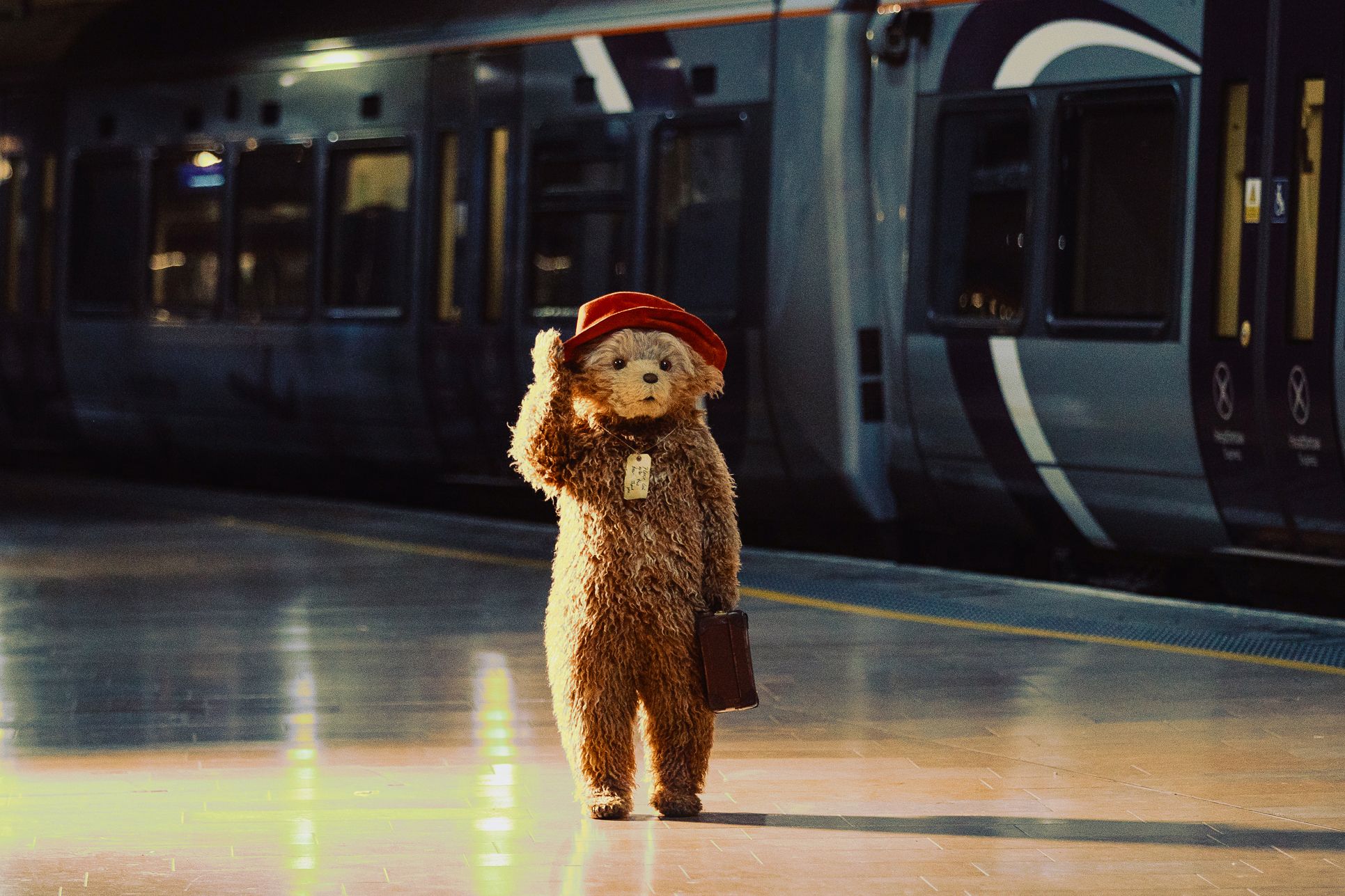 Paddington Bear walking through a train station 