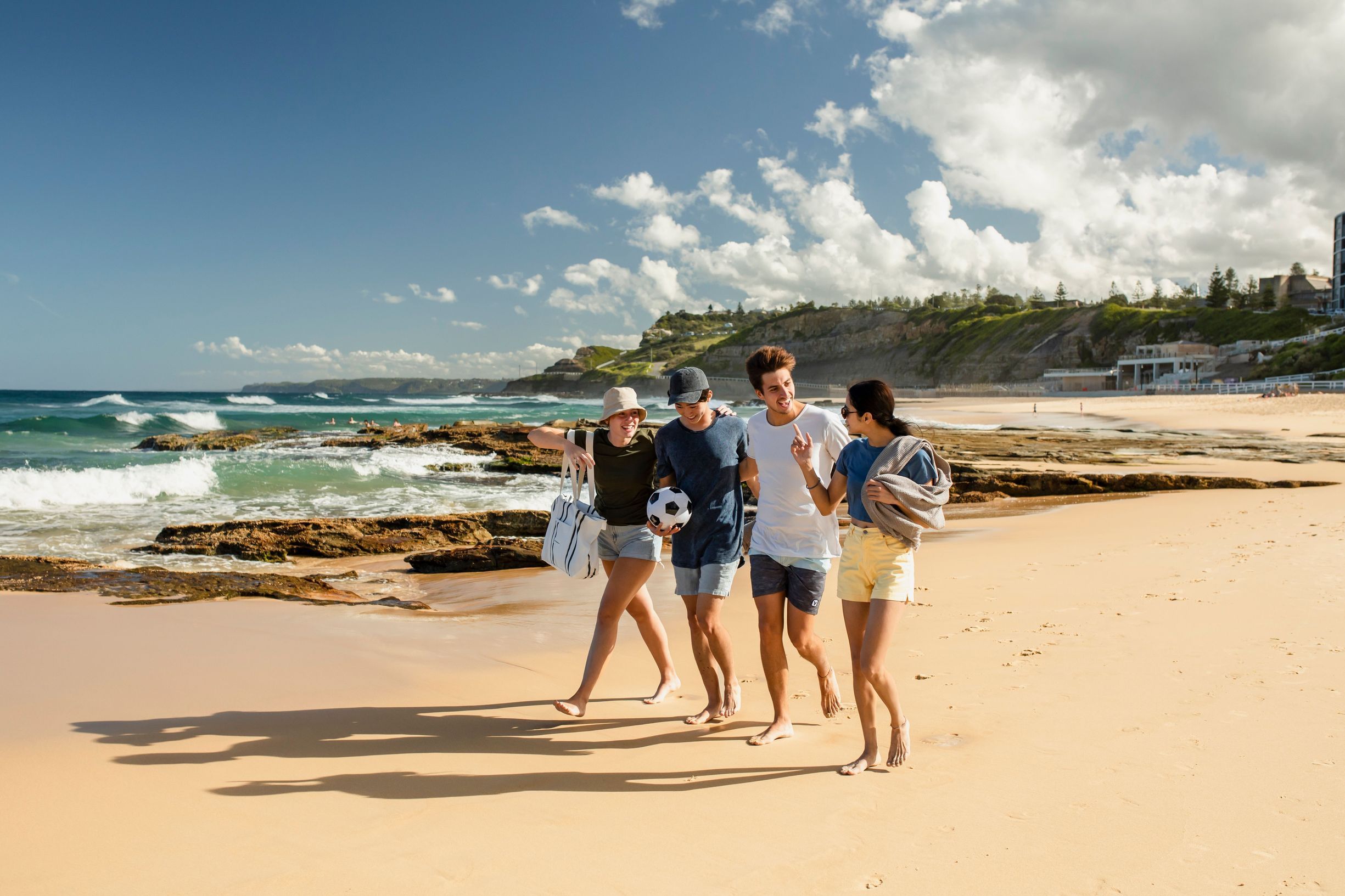 Group of friends walking on a Newcastle beach