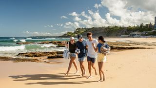 Group of friends walking on a Newcastle beach