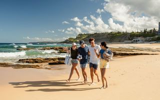 Group of friends walking on a Newcastle beach
