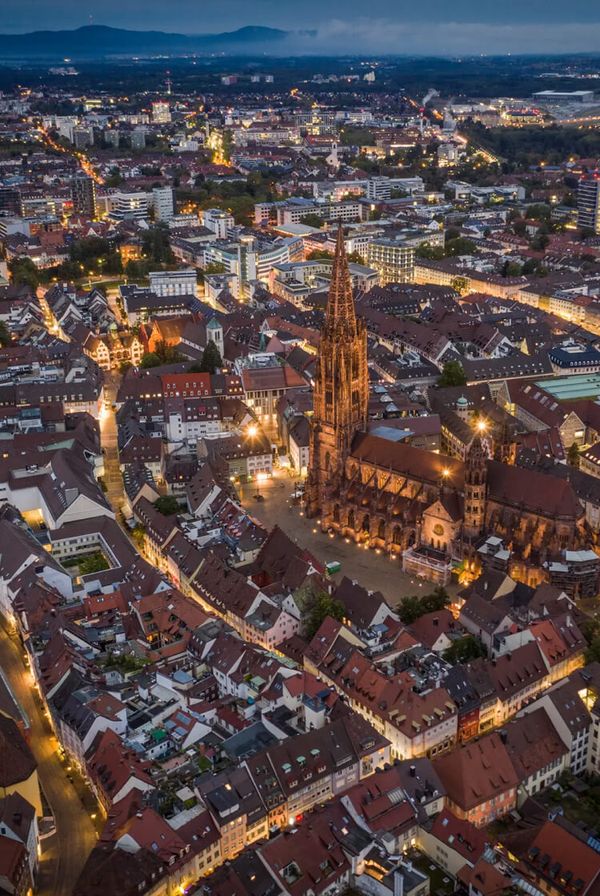 Luftaufnahme der Stadt Freiburg im Breisgau bei Nacht.