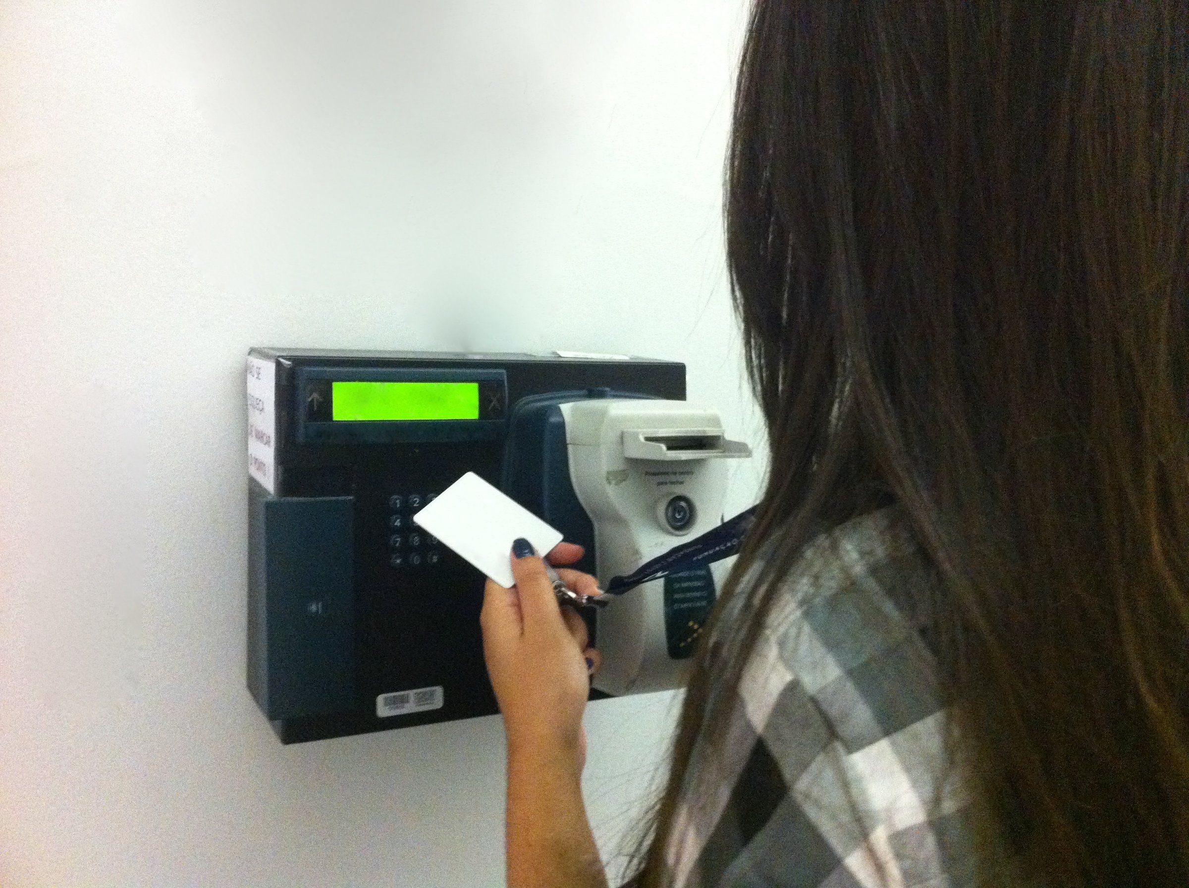 Una persona registra su entrada en un reloj checador electrónico.