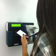 Una persona registra su entrada en un reloj checador electrónico.