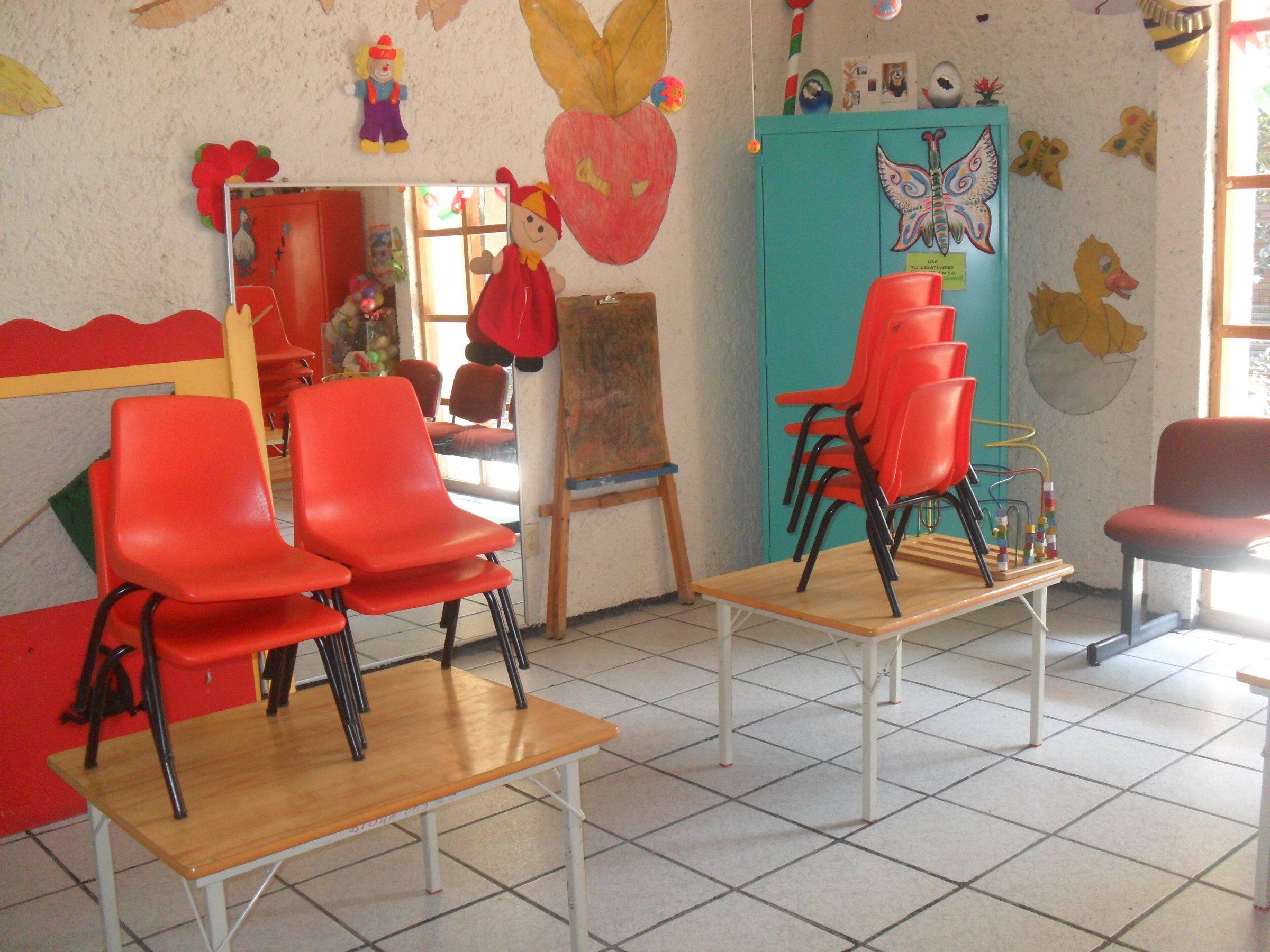 Salón de clases con mesas y sillas infantiles en un centro educativo de la Ciudad de México.