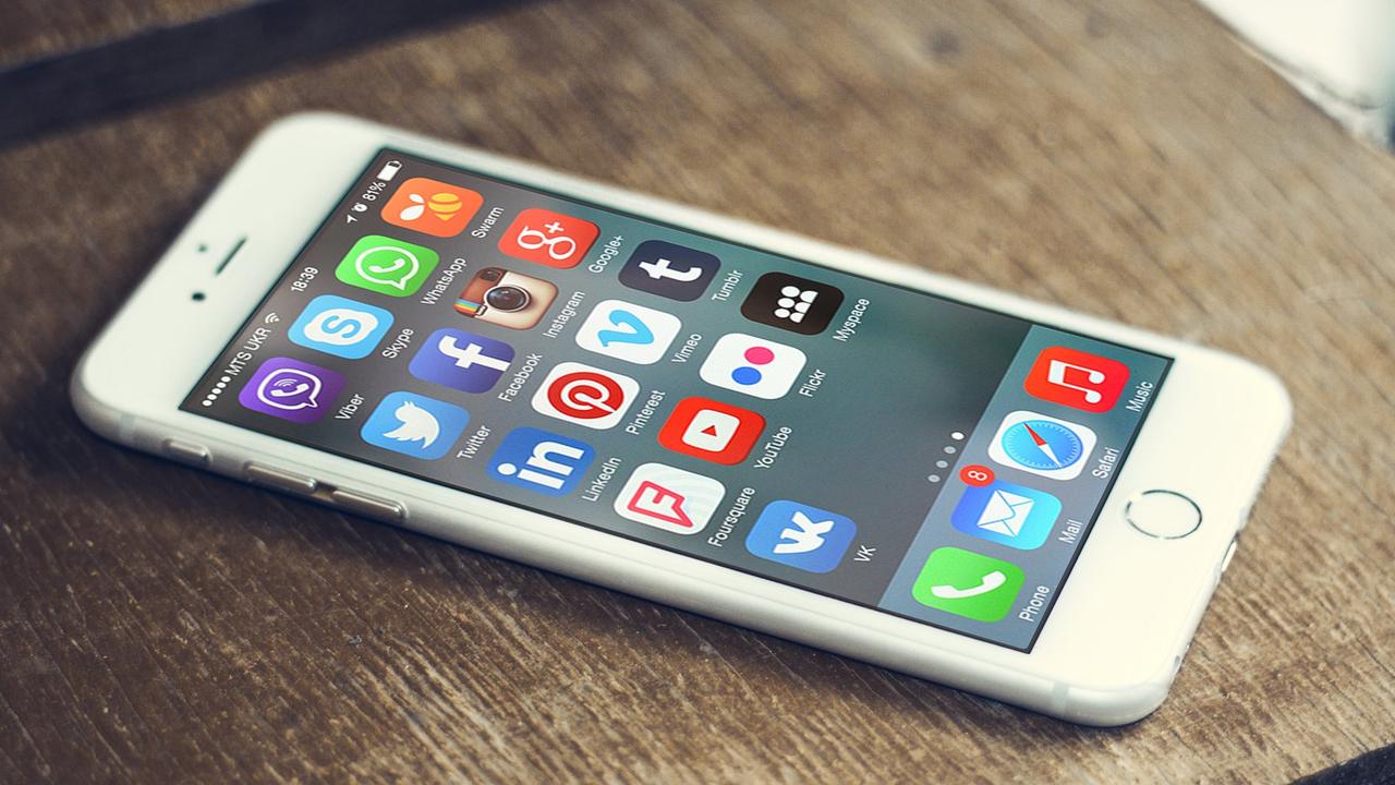 Un teléfono inteligente sobre una mesa de madera muestra en la pantalla los íconos de varias aplicaciones de redes sociales (imagen de archivo).