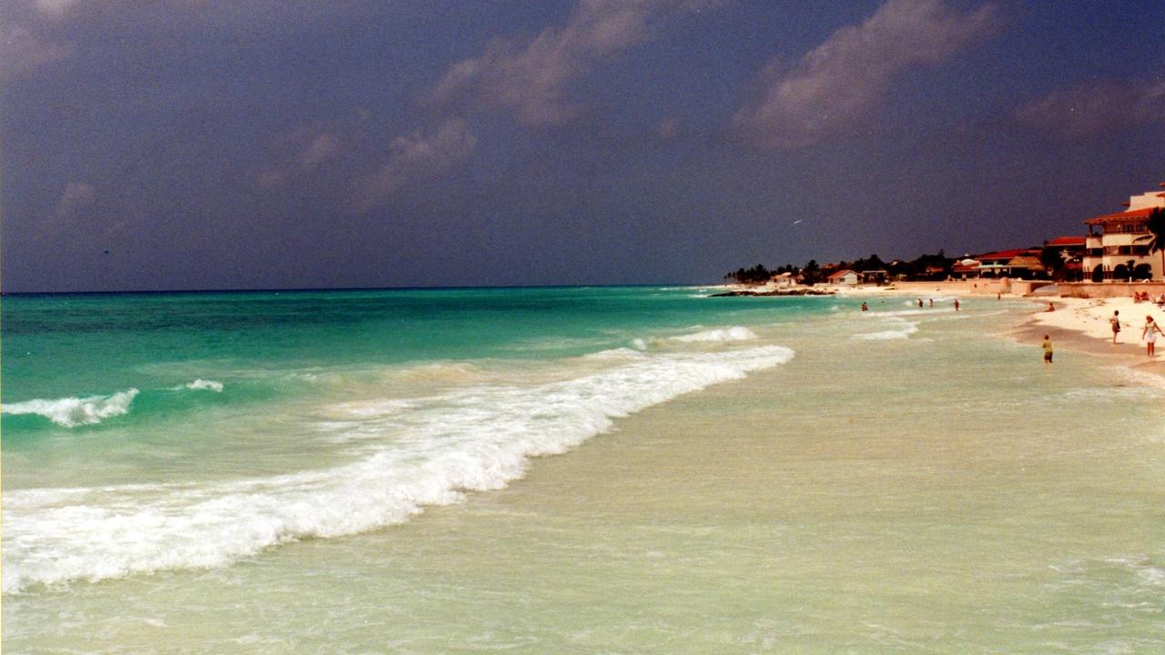 Ola rompiendo en la playa de Playa del Carmen, Quintana Roo, con hoteles al fondo (imagen de archivo).