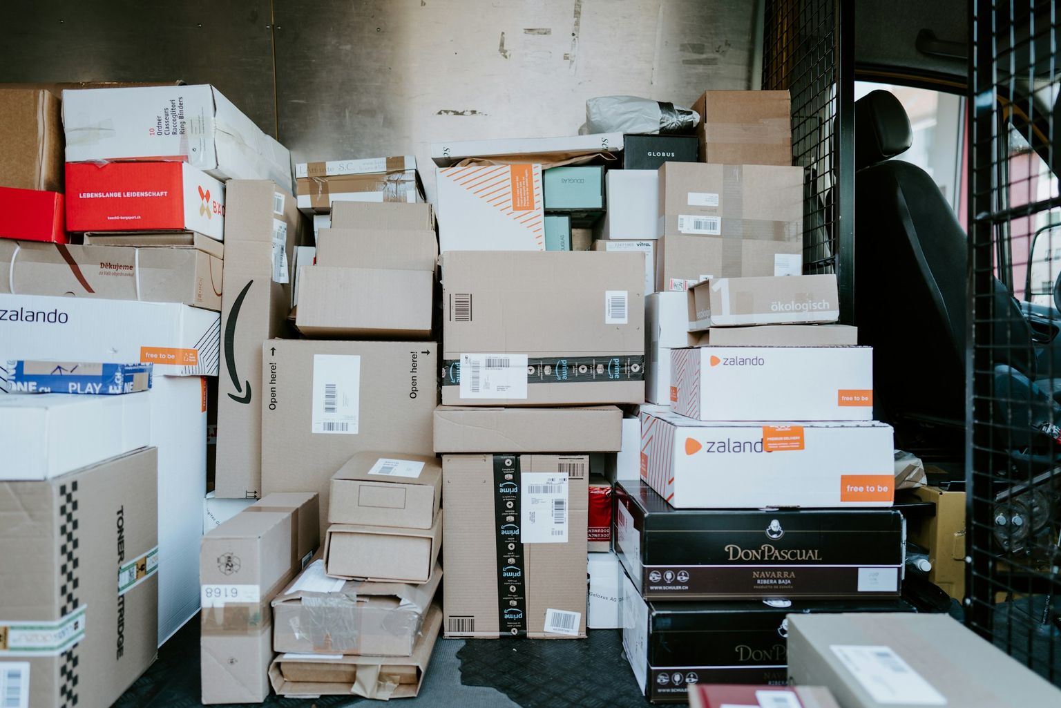 Cardboard shipping boxes stacked in the back of a delivery van