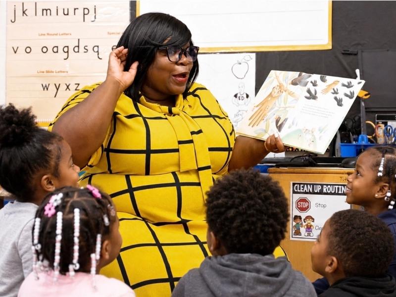 Dr. Takiwi reading aloud to students in a classroom