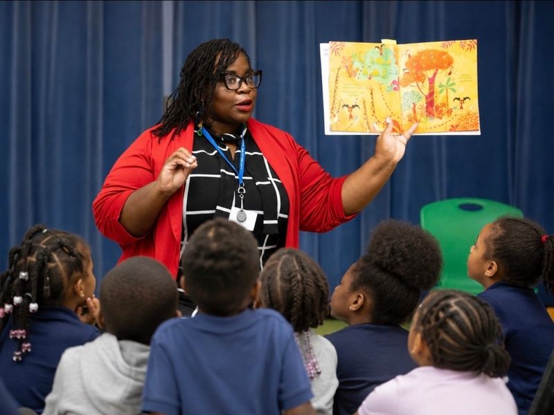 Dr. Takiwi reading with elementary students