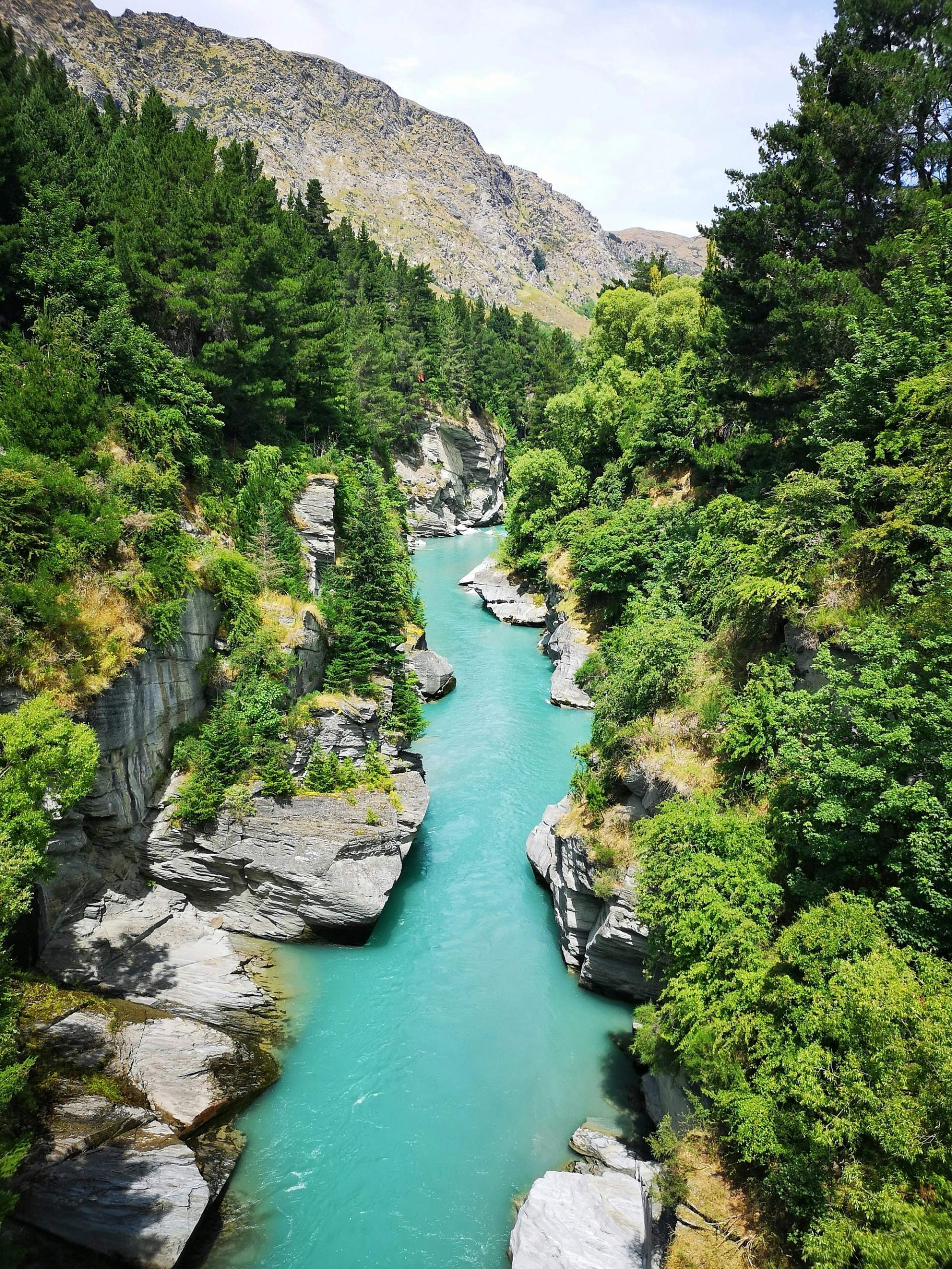 Turquoise waters of the Shotover River winding through a rocky gorge in Queenstown