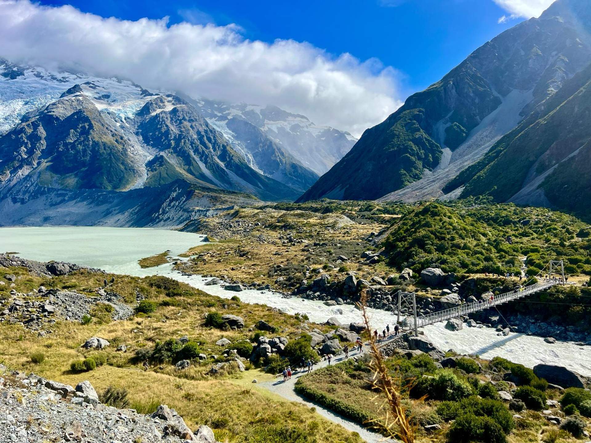 Snow-capped mountains and suspension bridge crossing the Hooker River in Aoraki/Mount Cook National Park, New Zealand
