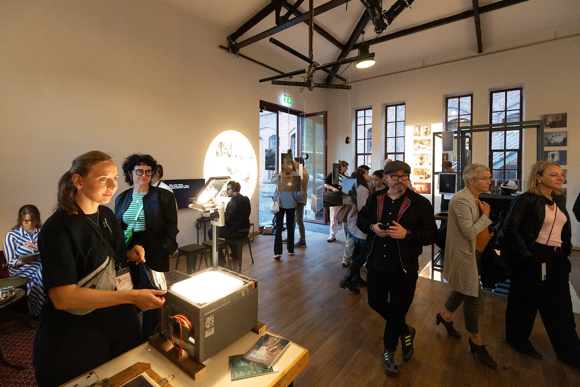 Visitors around an overhead projector in the exhibition.