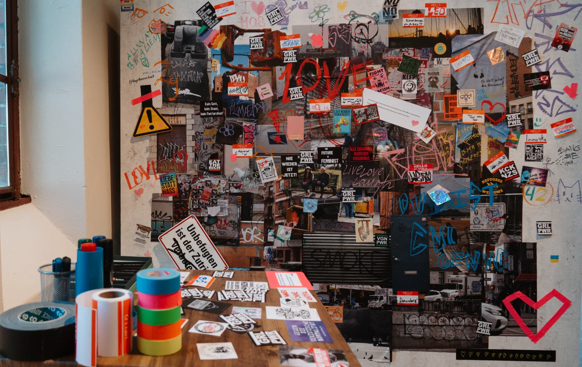 A colourful collage surrounded by drawing and workshop materials.