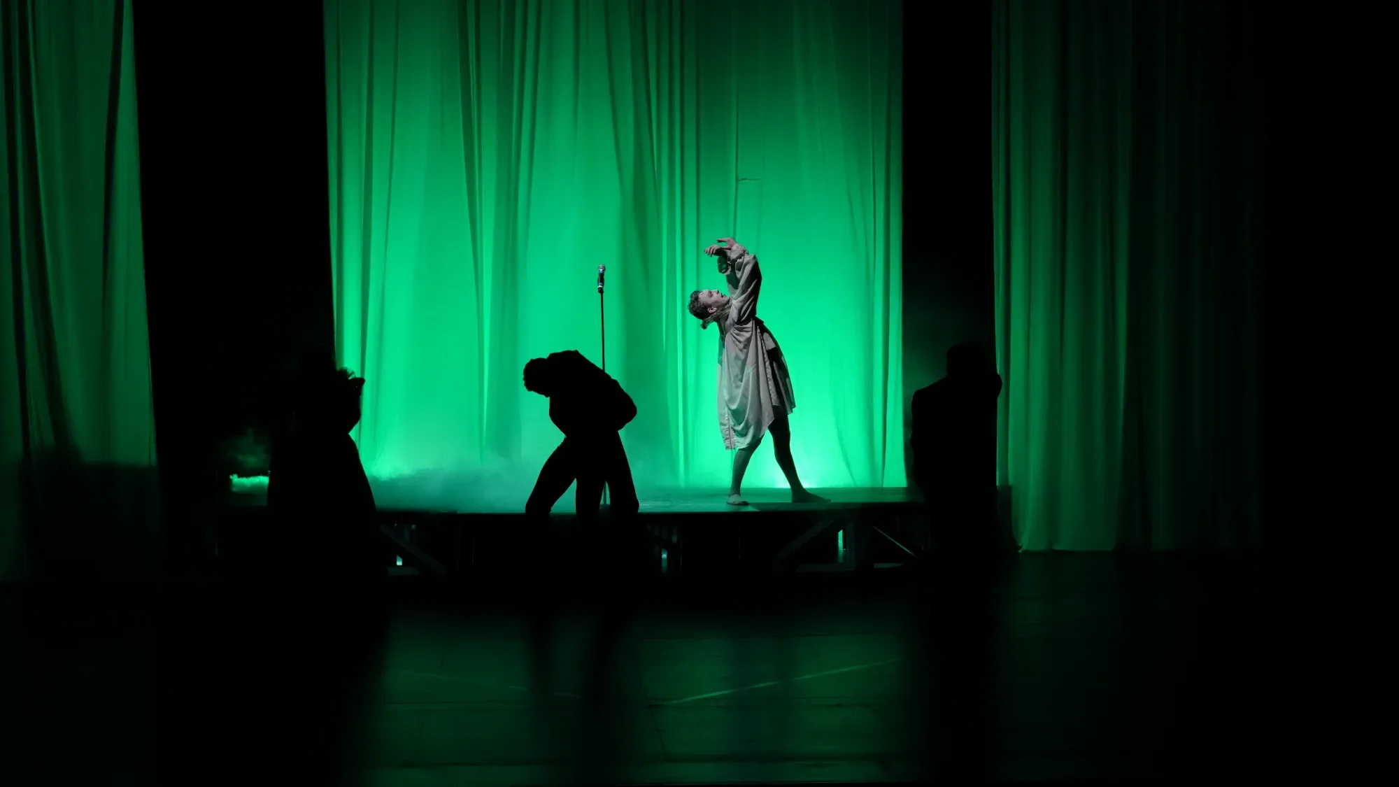 Green light, a figure above the silhouettes.
