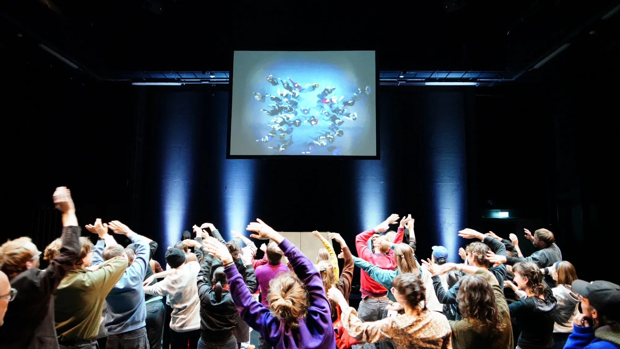 Spectators raise their hands on stage.
