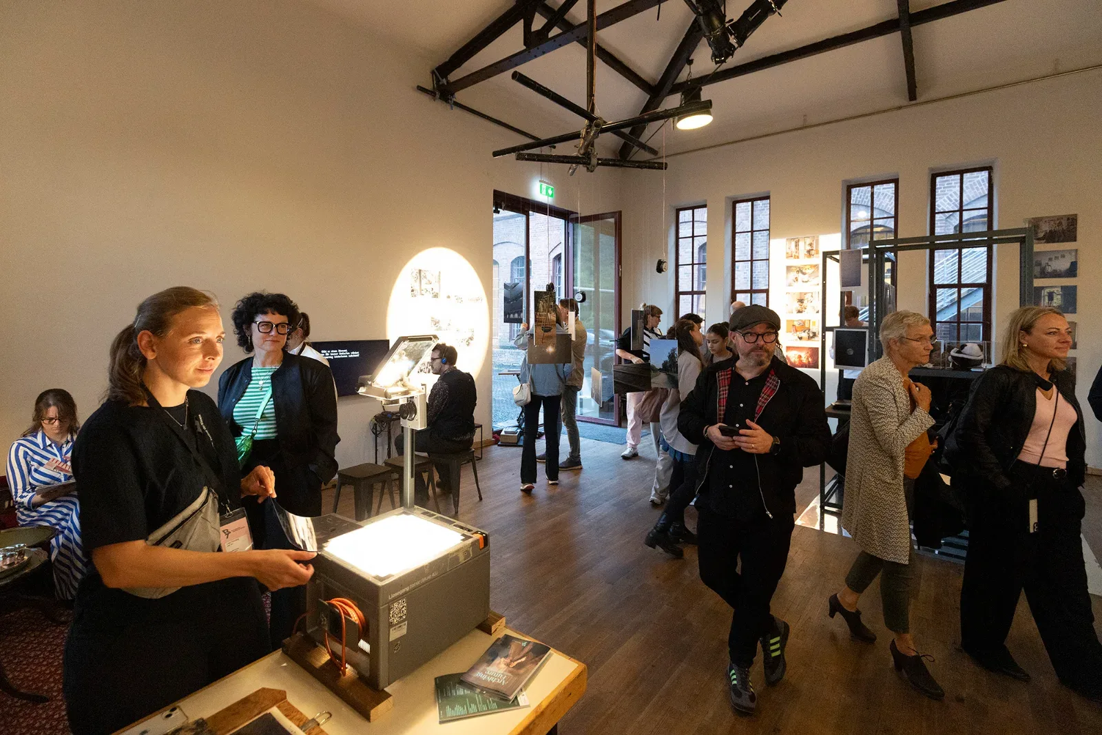 Visitors in the Archiving Future exhibition around an overhead projector.