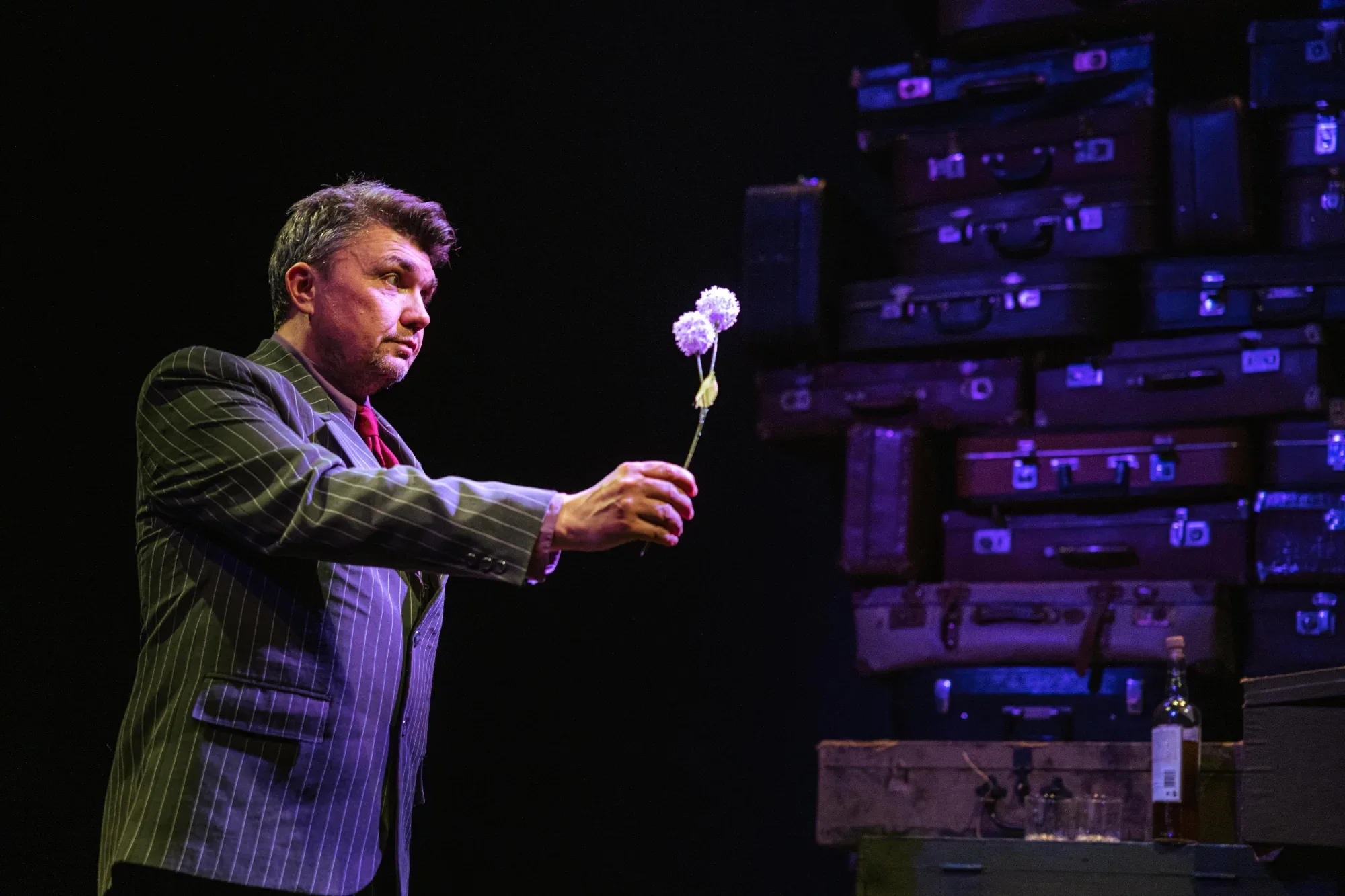 He holds out a flower.