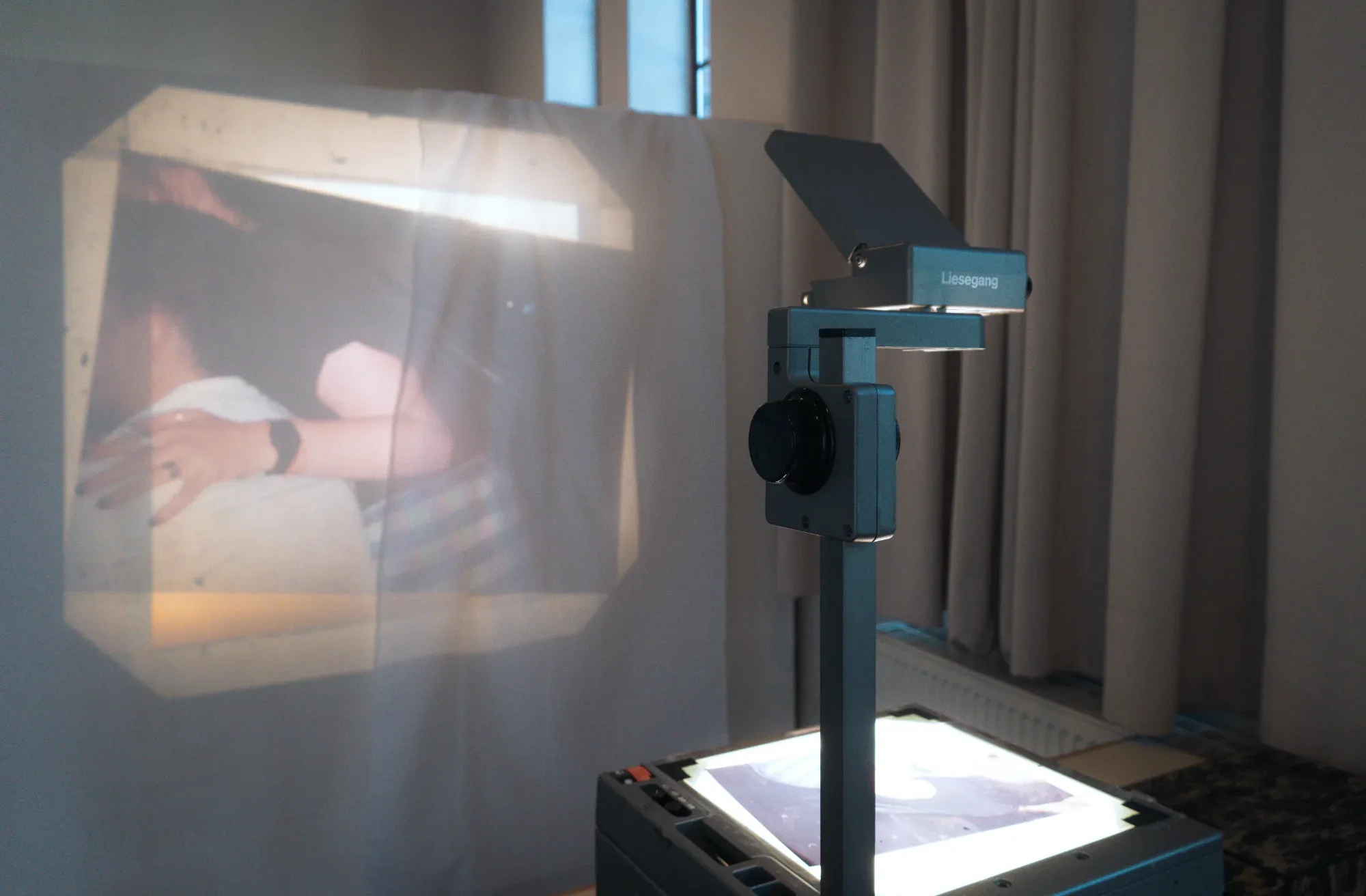 An overhead projector casts an image onto the exhibition wall.