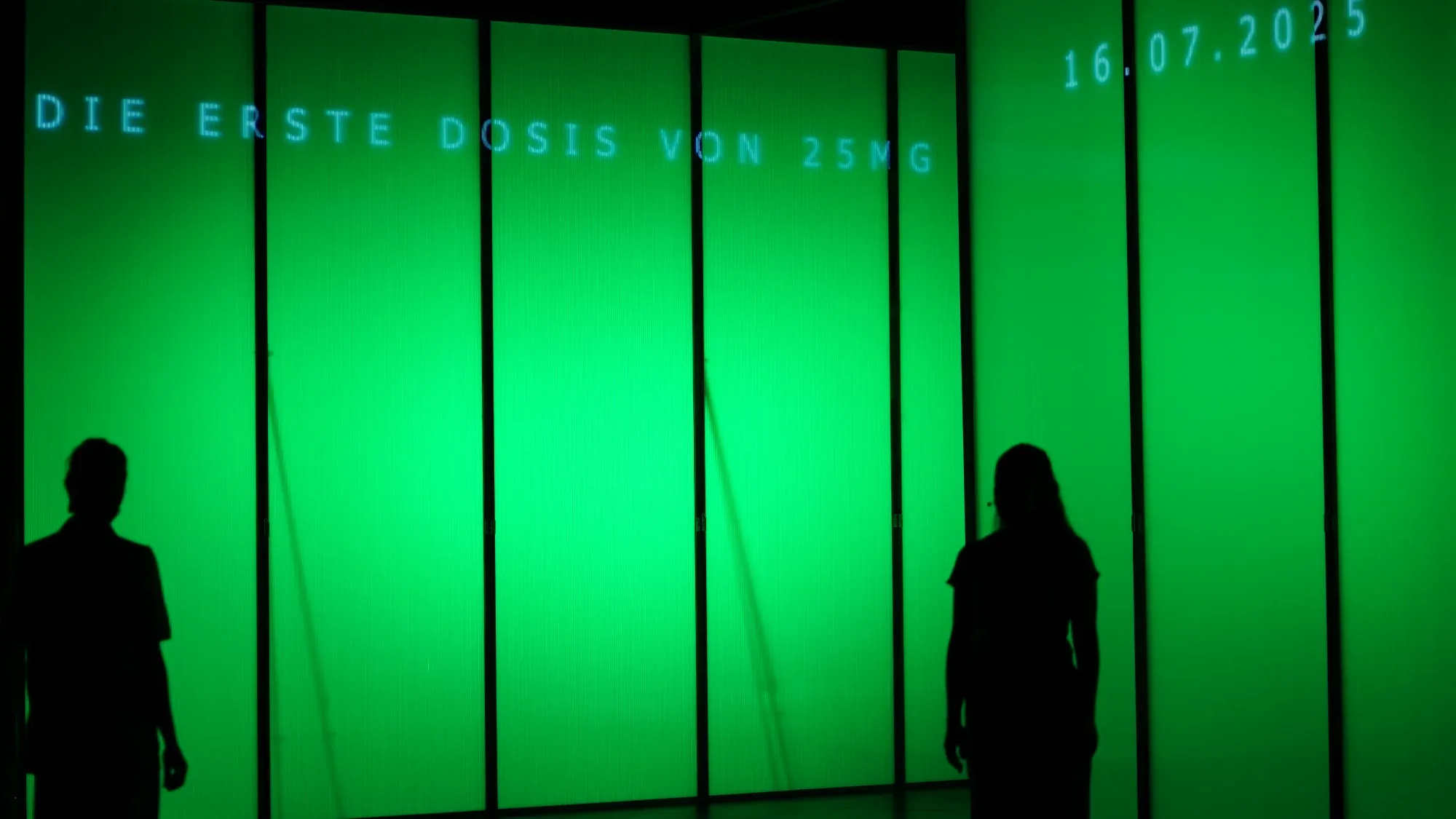 The trial begins: “Die erste Dosis …” (“The first dose …”) on the wall.