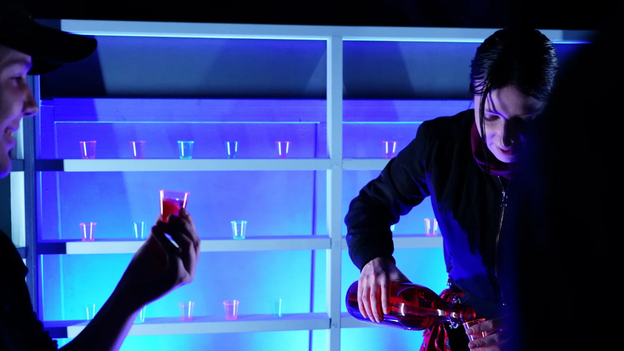 Drinks are poured at a glowing bar.