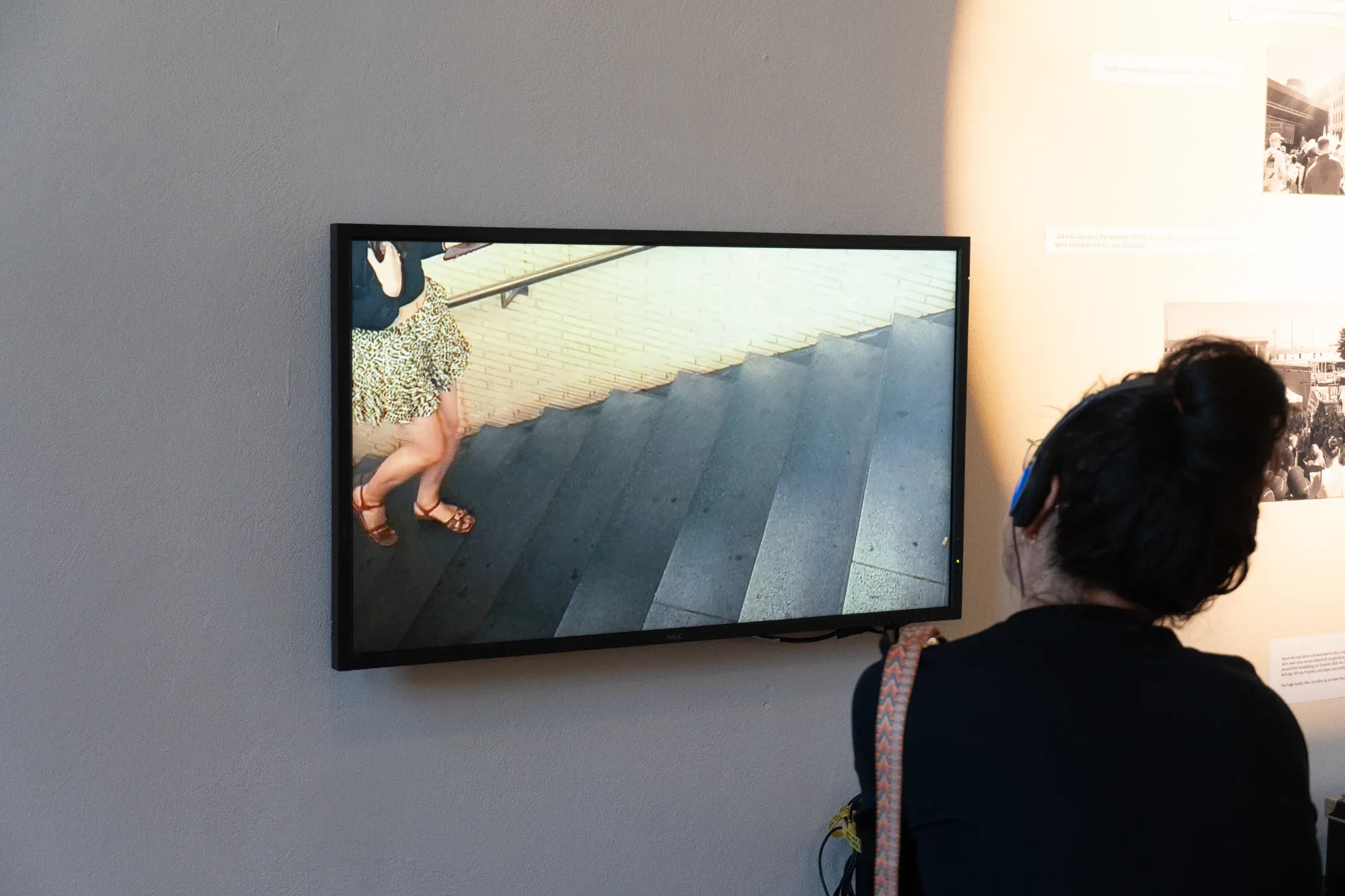 A visitor watches a video work on a screen.