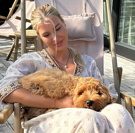 Ada i solstol med labradoodle i famnen