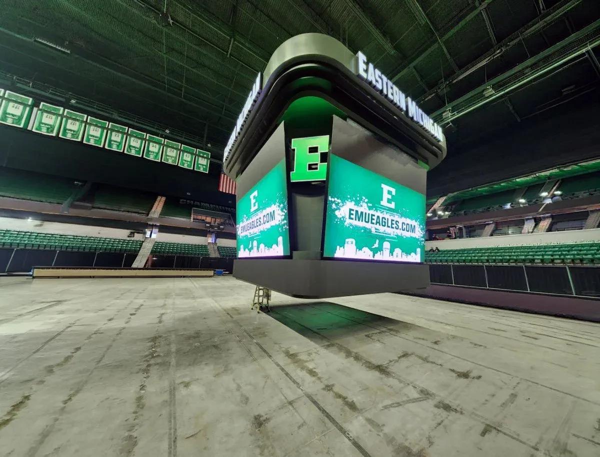Center-hung video scoreboard with green Eastern Michigan graphics above an empty arena floor
