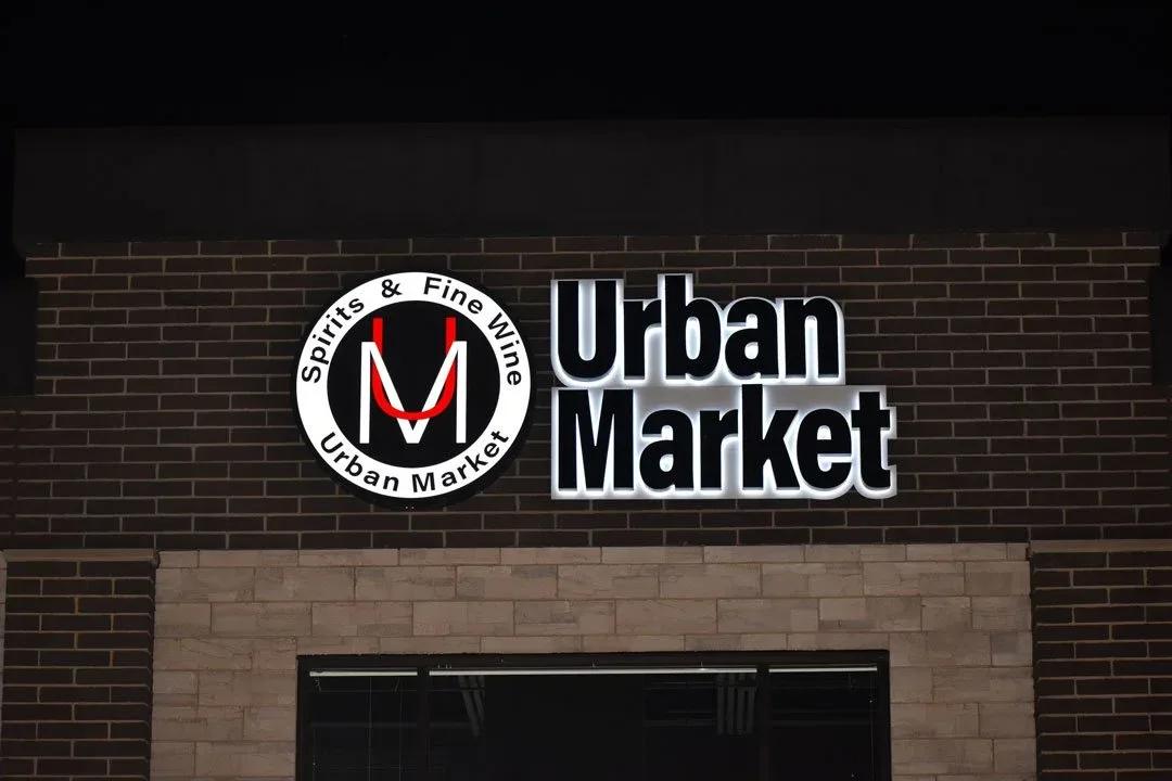 Urban Market illuminated letters and round logo on a brick wall