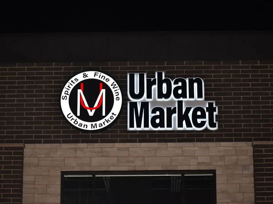 Urban Market illuminated letters and round logo on a brick wall