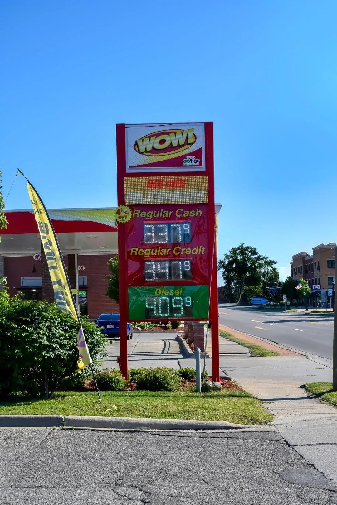 WOW price sign with LED fuel prices on a red pylon beside the road