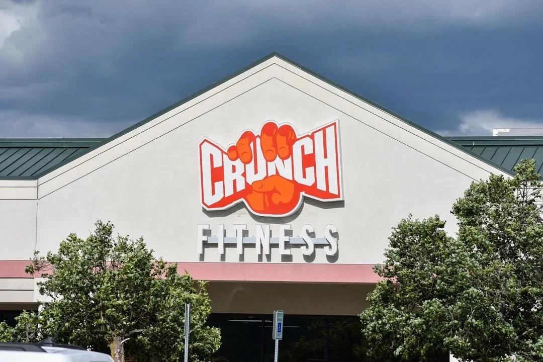 Crunch Fitness logo and letters on a gabled building front