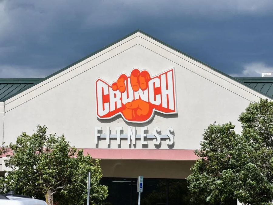 Crunch Fitness logo and letters on a gabled building front