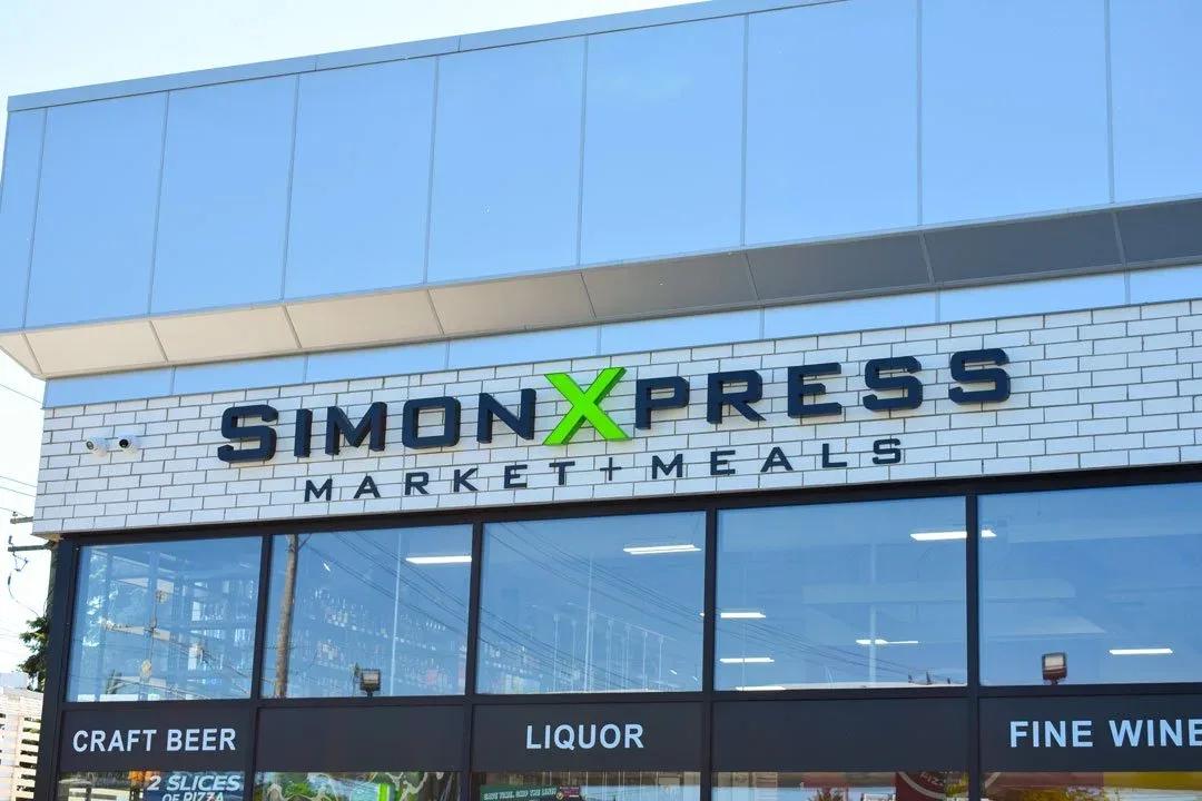 Simon Xpress Market and Meals letters on a white storefront